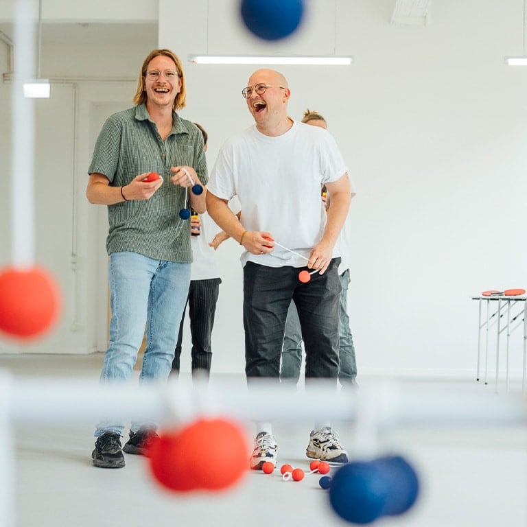 Zwei lachende Männer genießen Tischspiele bei einem Junggesellenabschied, organisiert von Your Showdown GmbH